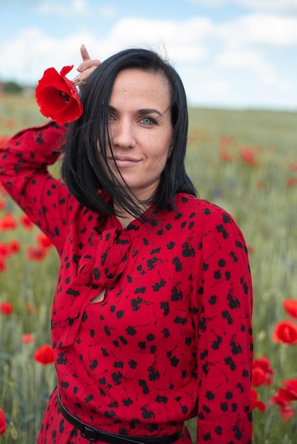 Jovem mulher bonita no campo de papoilas de flores de verão