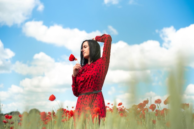 Jovem mulher bonita no campo de papoilas de flores de verão