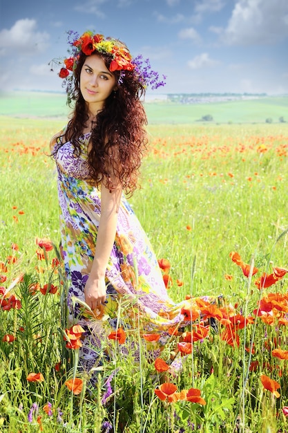 Jovem mulher bonita no campo de papoulas