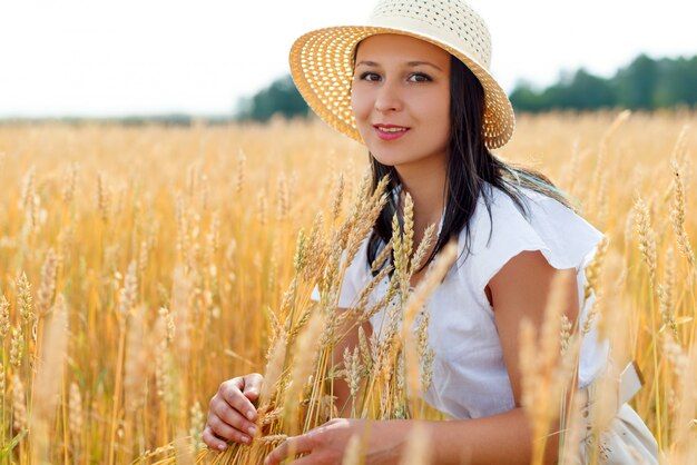 Jovem mulher bonita no campo de trigo dourado