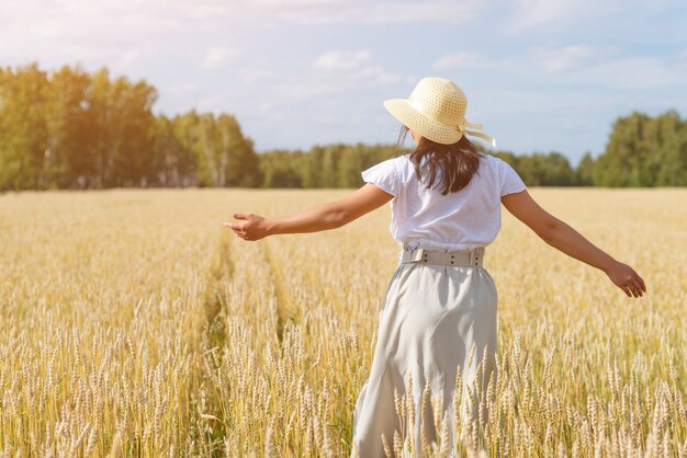 Jovem mulher bonita no campo de trigo dourado