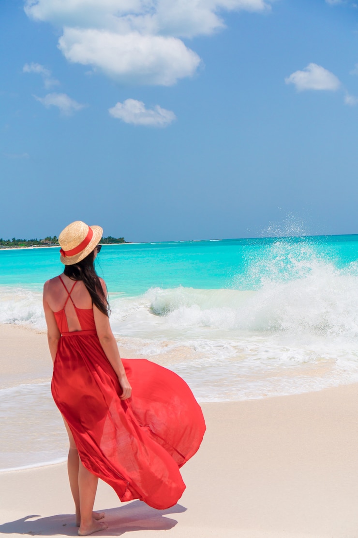 Foto jovem mulher bonita no vestido vermelho na beira-mar tropical