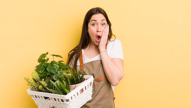 Jovem mulher bonita olhando animada e surpresa apontando para o conceito de plantas laterais