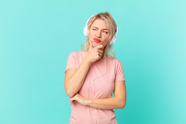 Jovem mulher bonita pensando sentindo-se duvidoso e confuso ouvindo o conceito de música