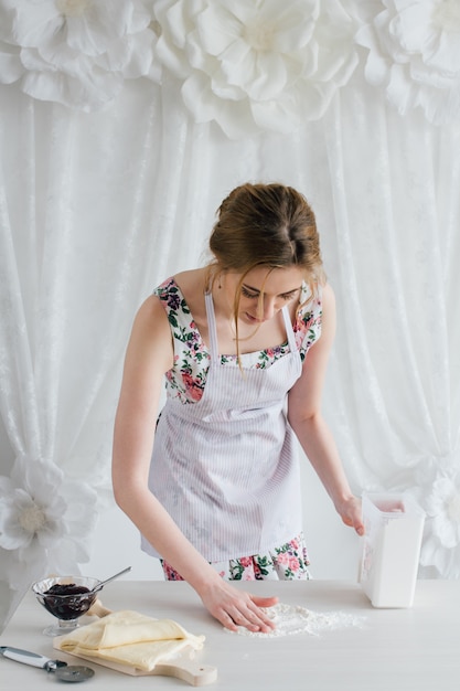 Jovem mulher bonita preparando croissants caseiros