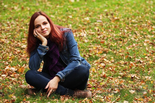 Jovem mulher bonita relaxante no parque outono