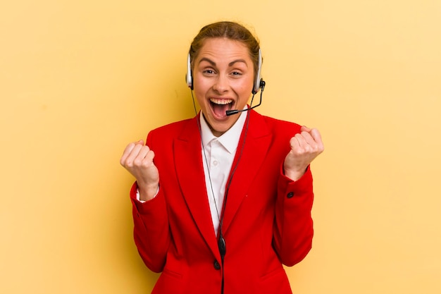 Jovem mulher bonita se sentindo chocada rindo e comemorando o conceito de telemarketing de sucesso