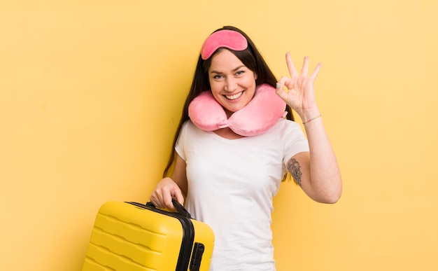 Jovem mulher bonita se sentindo feliz mostrando aprovação com o conceito de passageiro de voo de gesto bem