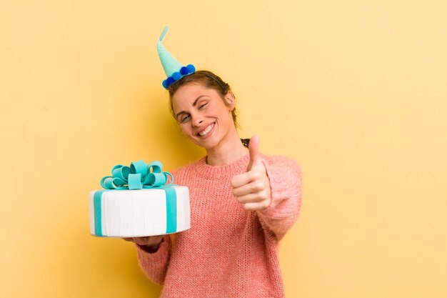 Jovem mulher bonita se sentindo orgulhosa sorrindo positivamente com polegares para cima conceito de aniversário