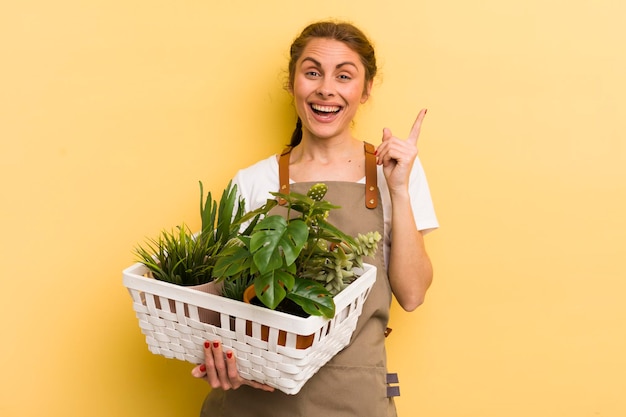 Jovem mulher bonita se sentindo um gênio feliz e animado depois de perceber um conceito de plantas de ideia