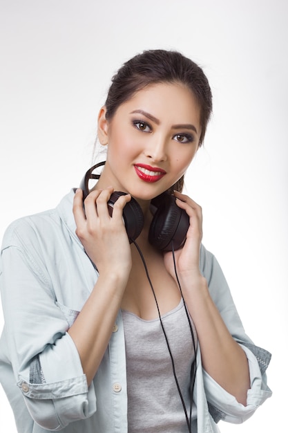 Jovem mulher bonita segurando fones de ouvido grandes isolados