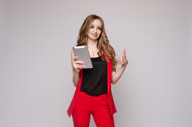 Jovem mulher bonita segurando o tablet e lendo o livro nele