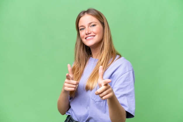 Jovem mulher bonita sobre fundo isolado surpreso e apontando para a frente