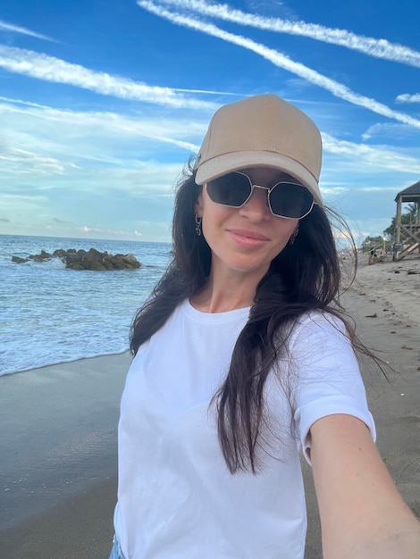 Jovem mulher bonita tomando selfie na praia