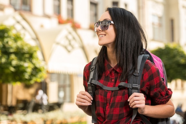 Foto jovem mulher bonita, turista com mochila, sorrindo.