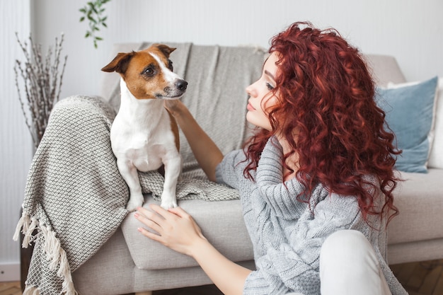 Jovem mulher brincando com seu cachorro