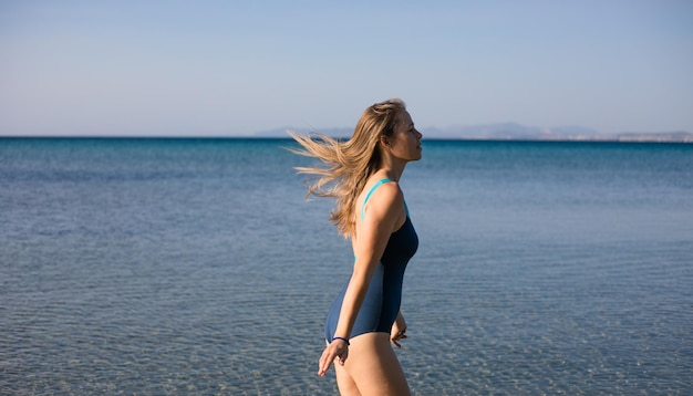 Jovem mulher brincando no mar no verão mulher desfrutando na água do mar Jovem alegre se divertindo na praia Ela está relaxada na água do mar e gosta de férias