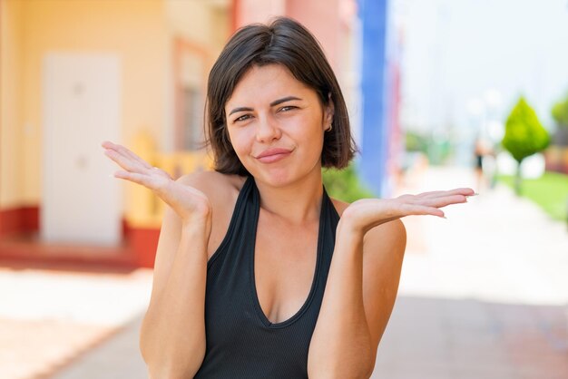 Foto jovem mulher búlgara bonita ao ar livre fazendo gestos de dúvidas