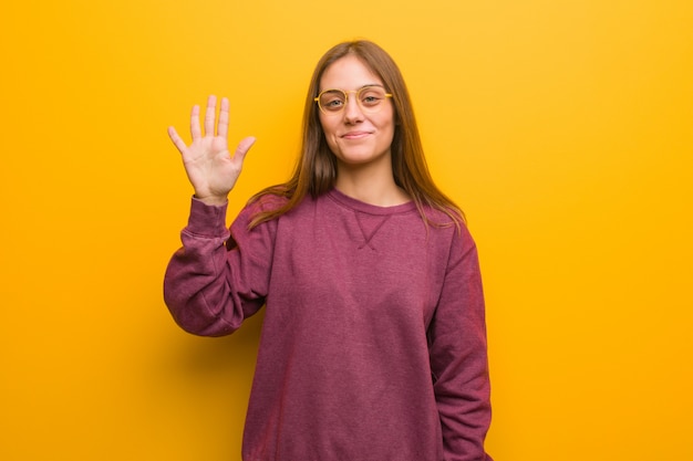 Jovem mulher casual mostrando o número cinco