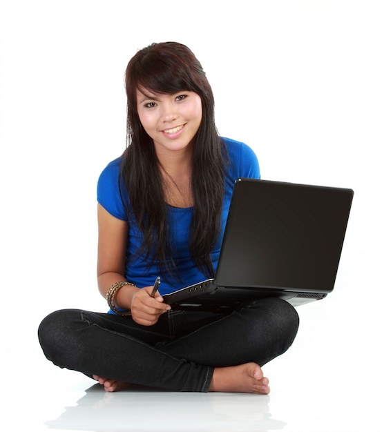 Jovem mulher casual sentado sorrindo segurando laptop