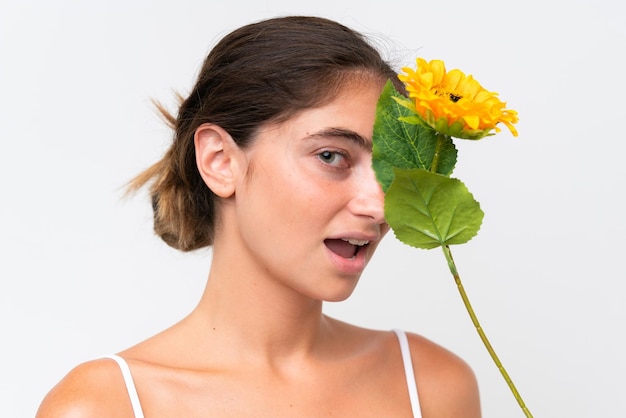 Jovem mulher caucasiana bonita isolada em fundo branco segurando um girassol Retrato em close-up