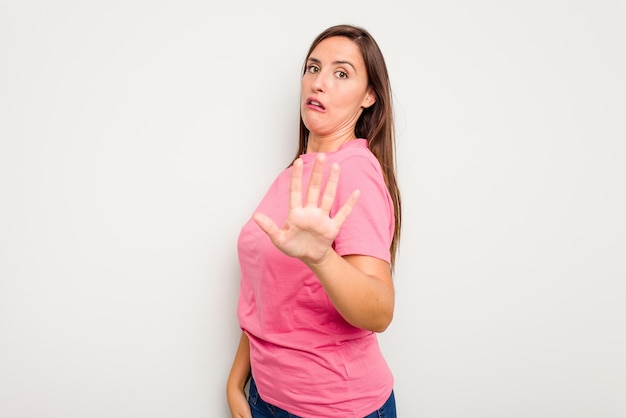 Jovem mulher caucasiana bonita isolada em fundo branco sendo chocada devido a um perigo iminente