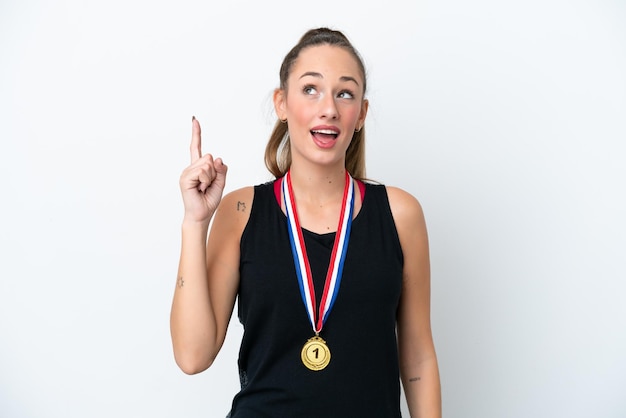 Jovem mulher caucasiana com medalhas isoladas em fundo branco com a intenção de perceber a solução enquanto levanta um dedo