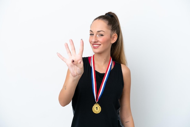 Jovem mulher caucasiana com medalhas isoladas em fundo branco feliz e contando quatro com os dedos