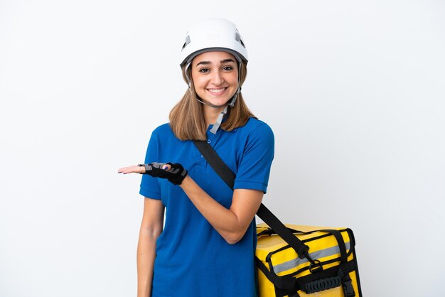 Jovem mulher caucasiana com mochila térmica isolada em fundo branco apresentando uma ideia enquanto olha sorrindo para