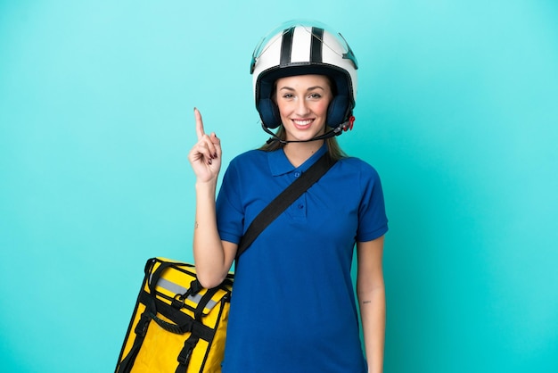 Jovem mulher caucasiana com mochila térmica isolada em fundo branco mostrando e levantando um dedo em sinal do melhor