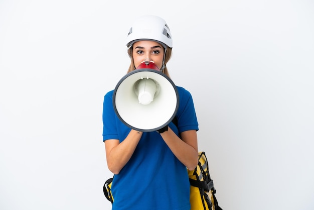 Jovem mulher caucasiana com mochila térmica isolada no fundo branco gritando através de um megafone
