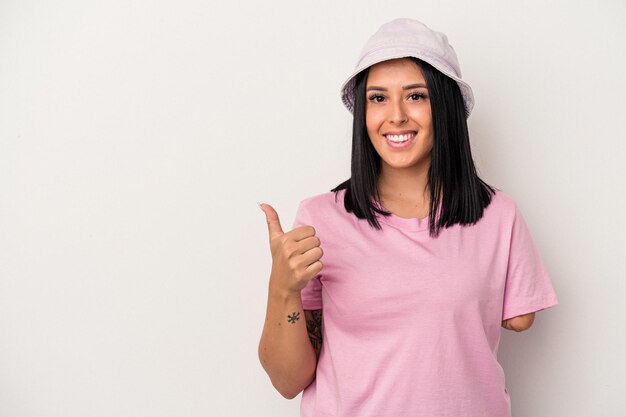 Jovem mulher caucasiana com um braço isolado no fundo branco, sorrindo e levantando o polegar