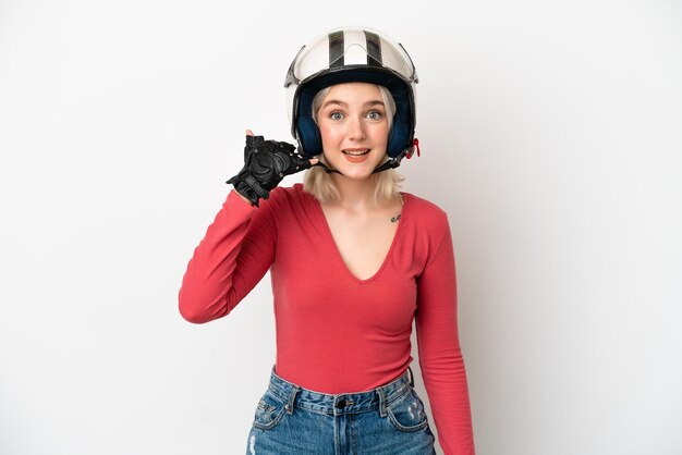 Jovem mulher caucasiana com um capacete de moto isolado no fundo branco, fazendo um gesto de telefone, ligue para mim de volta