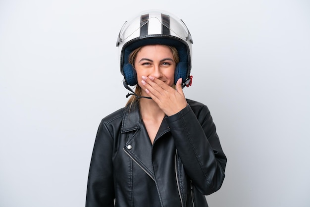 Jovem mulher caucasiana com um capacete de moto isolado no fundo branco feliz e sorridente cobrindo a boca com a mão