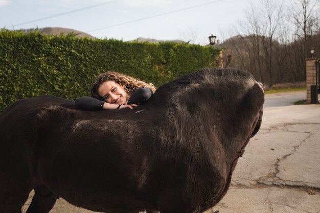 Jovem mulher caucasiana com um cavalo em um centro equestre