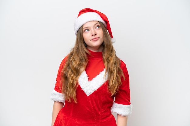 Jovem mulher caucasiana com vestido de Natal isolado no fundo branco e olhando para cima