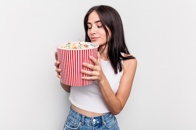 Jovem mulher caucasiana comendo pipoca isolada no fundo branco