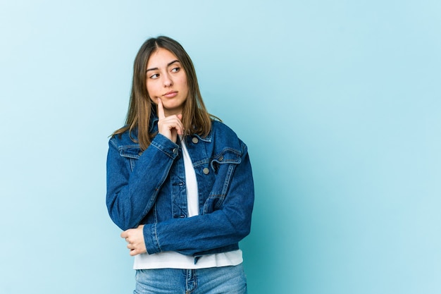 Jovem mulher caucasiana contemplando, planejando uma estratégia, pensando