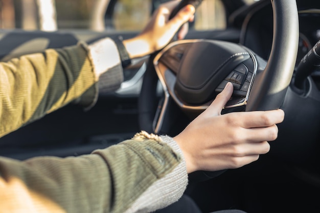 Jovem mulher caucasiana de mãos dadas no volante Pela mão direita, ela está mudando de faixa