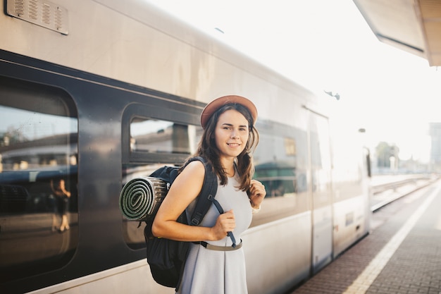 Jovem mulher caucasiana de retrato com sorriso no pé da estação de trem