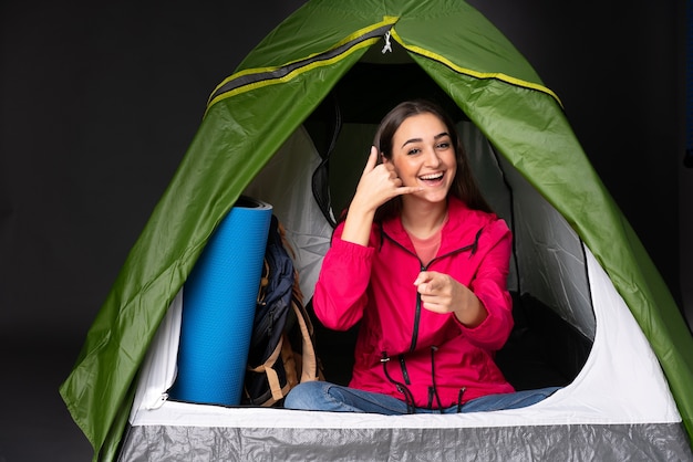 Foto jovem mulher caucasiana dentro de uma barraca de acampamento verde