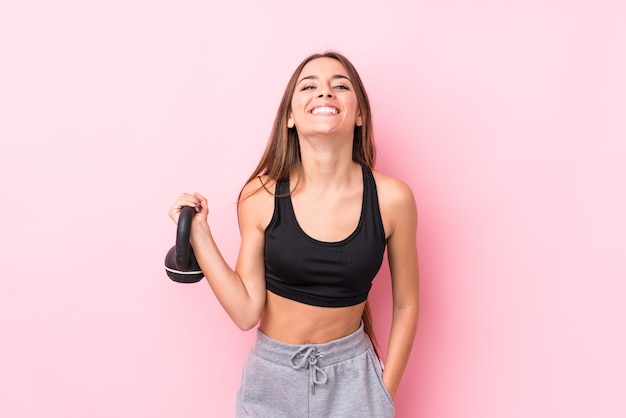 Jovem mulher caucasiana e desportiva segurando um kettlebell