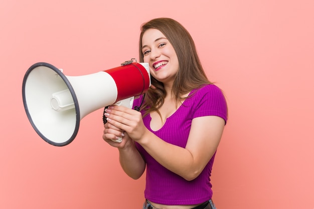 Jovem mulher caucasiana falando através de um megafone