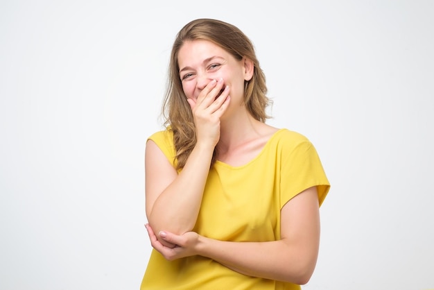 Foto jovem mulher caucasiana fechando a boca e o olho bem aberto isolado no fundo branco