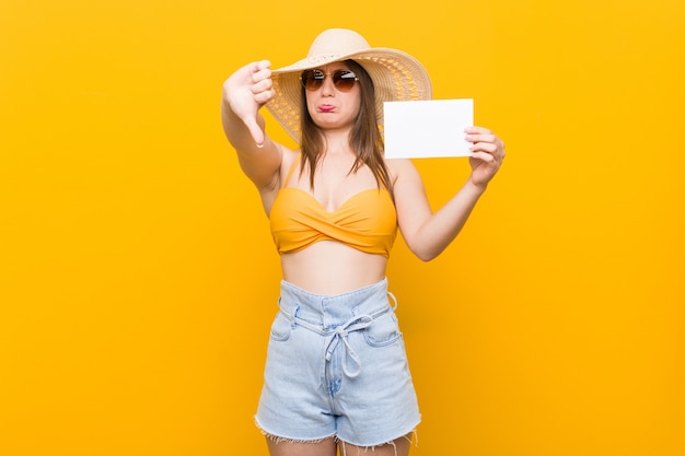 Jovem mulher caucasiana, indo às compras jovem mulher caucasiana, pronta para ir à praia com um cartaz