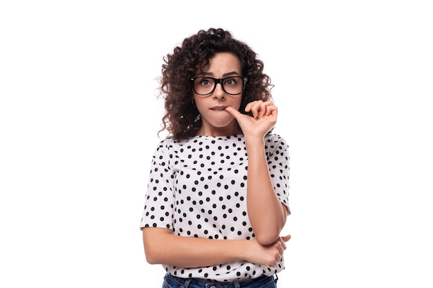 Jovem mulher caucasiana inteligente com cabelo perm encaracolado usa óculos para a imagem