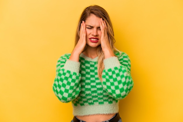 Jovem mulher caucasiana isolada em fundo amarelo choramingando e chorando desconsoladamente