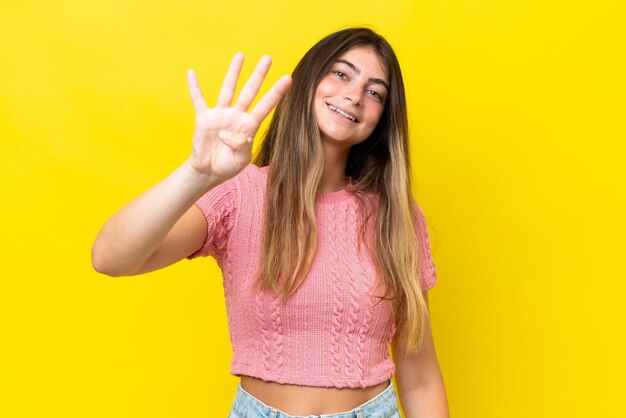 Jovem mulher caucasiana isolada em fundo amarelo feliz e contando quatro com os dedos