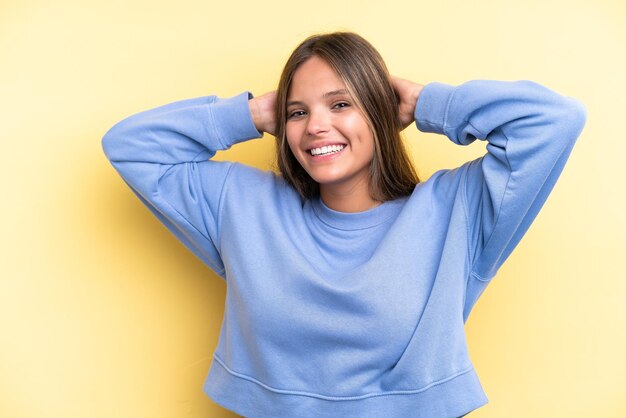 Jovem mulher caucasiana isolada em fundo amarelo rindo