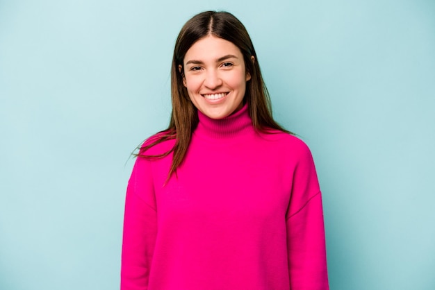 Jovem mulher caucasiana isolada em fundo azul feliz sorrindo e alegre